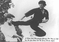 Author of How To Be Your Own Bodyguard shown doing a flying side kick on a student during training in the seventies